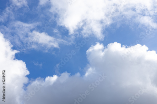 Detail of a white cloud in a bright blue sky. Dark rain clouds displace the blue sky. Storm is coming 