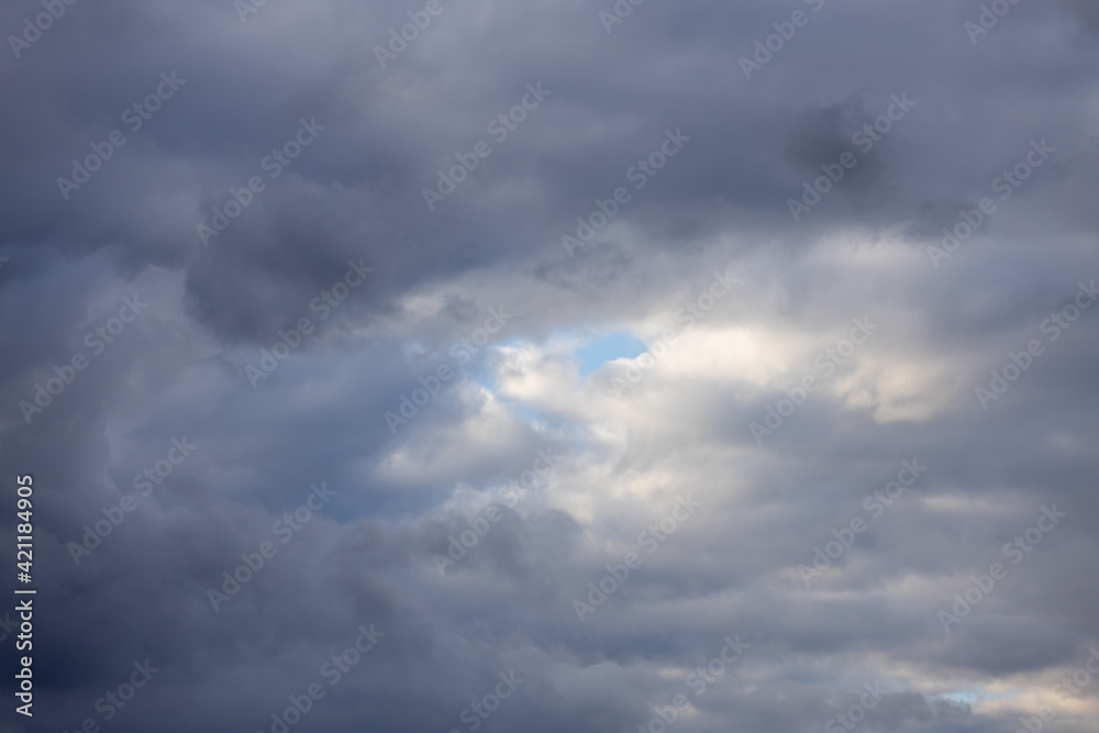Detail of a white cloud in a bright blue sky. 
Dark rain clouds displace the blue sky. Storm is coming 