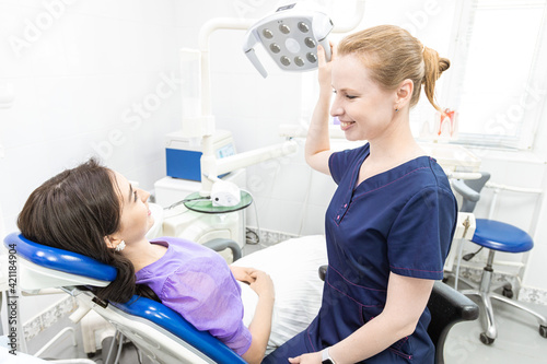 Dentistry concept. Professional dental services and modern equipment without pain. The doctor consults and treats the young woman  conducts an examination and draws up a treatment plan