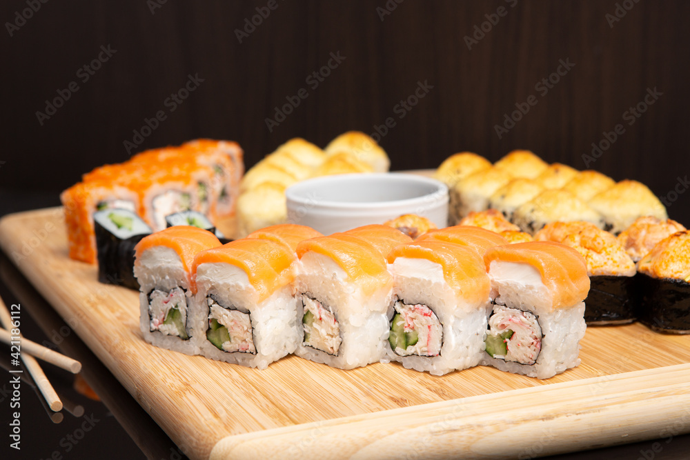 Big sushi set on light wooden dish isolated on black background Big sushi set on light wooden dish isolated on black background