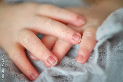 Hands of a newborn toddler on a light background