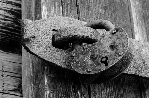 old hanging rusty iron lock on wooden door	
