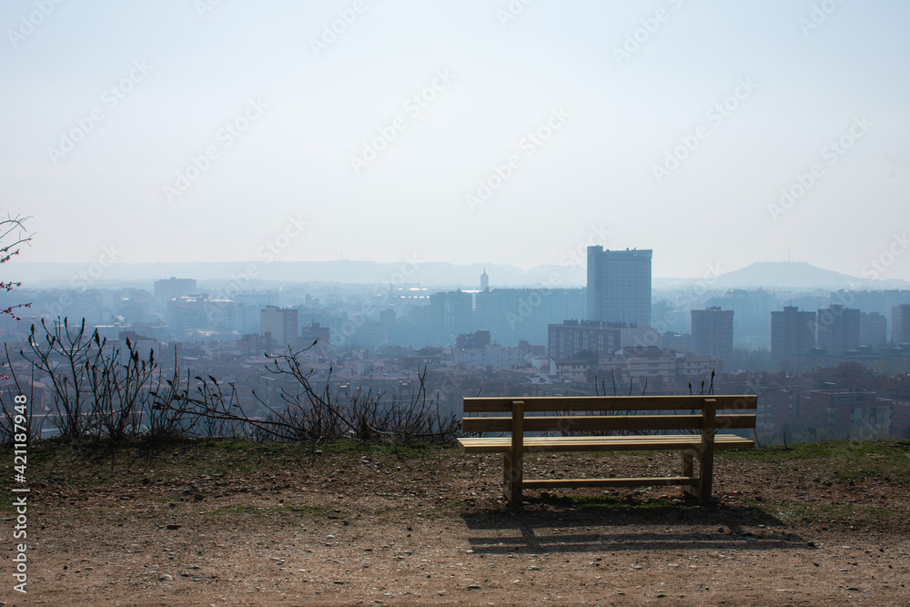 empty wooden bench in spring park over the city empty wooden bench in spring park over the city