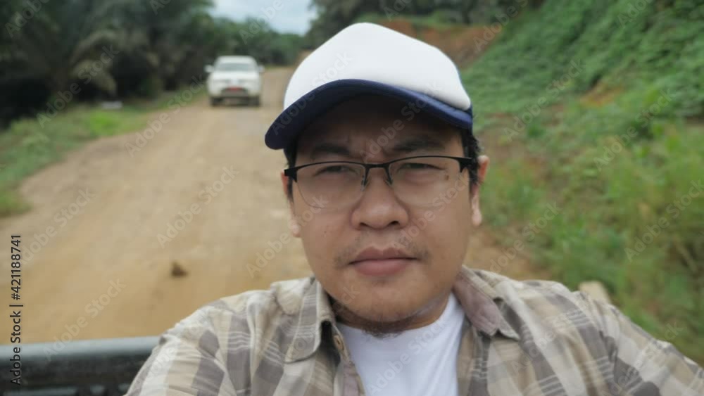 Asian man sitting in the back of pickup truck, outdoor safari trip adventure journey in the wild Asian man sitting in the back of pickup truck, outdoor safari trip adventure journey in the wild