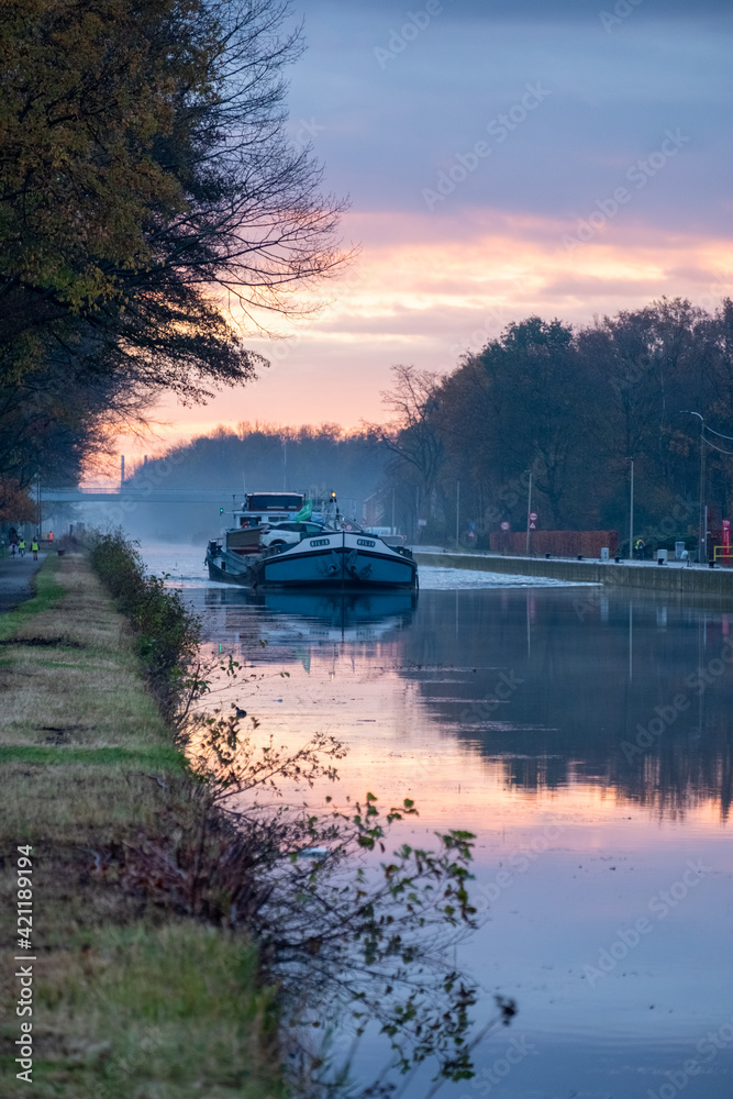 Cargo ship on a river during a misty sunrise morning. High quality photo