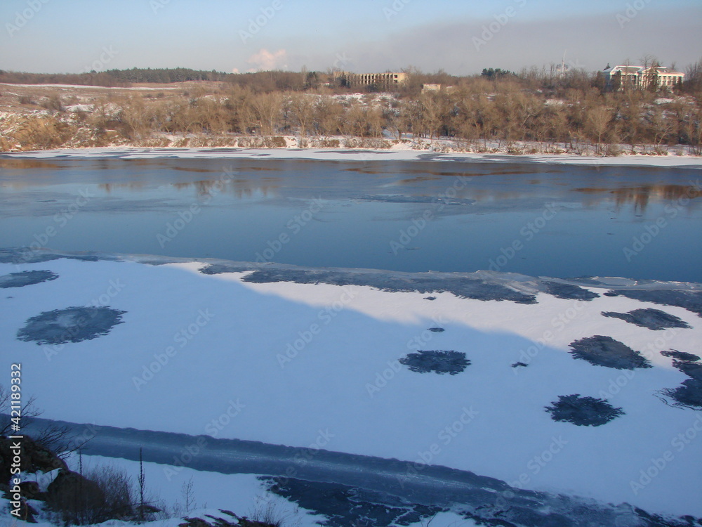 Landscape of the water surface of the wide Dnieper bound by an ice shell and covered with a fluffy blanket of snow.