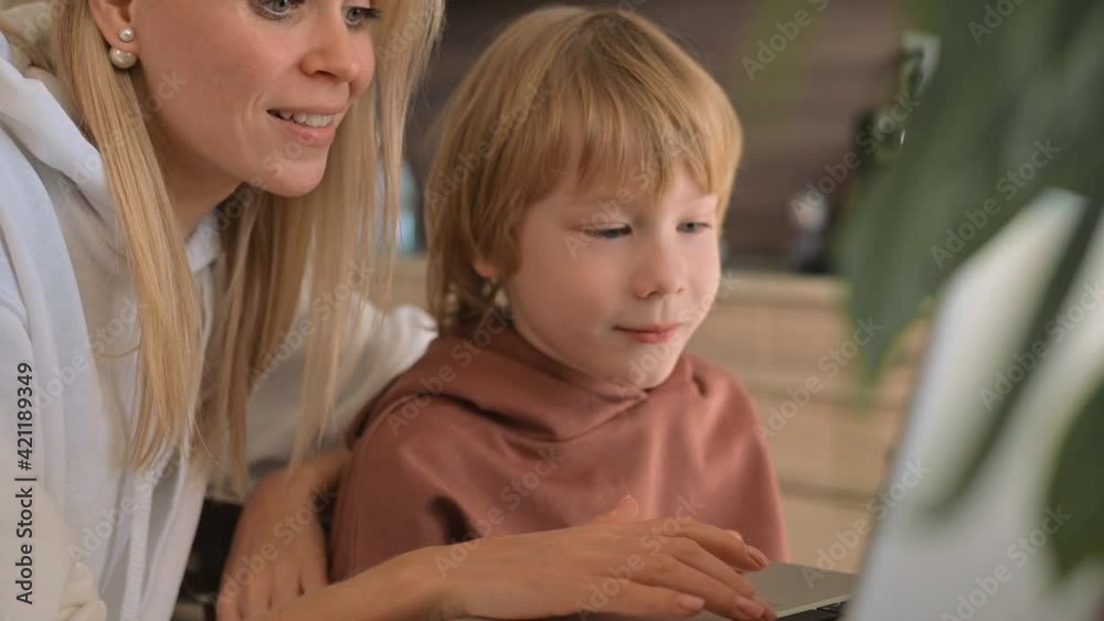 Little boy and mother using laptop and having fun at home Little boy and mother using laptop and having fun at home