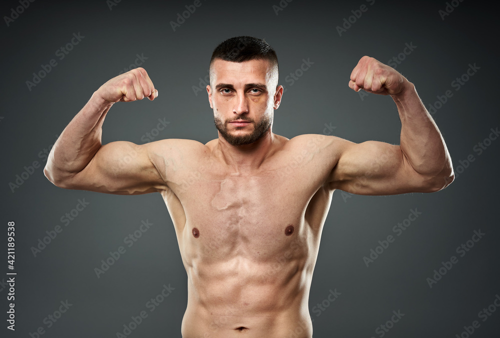 Athletic fighter posing on gray Athletic fighter posing on gray
