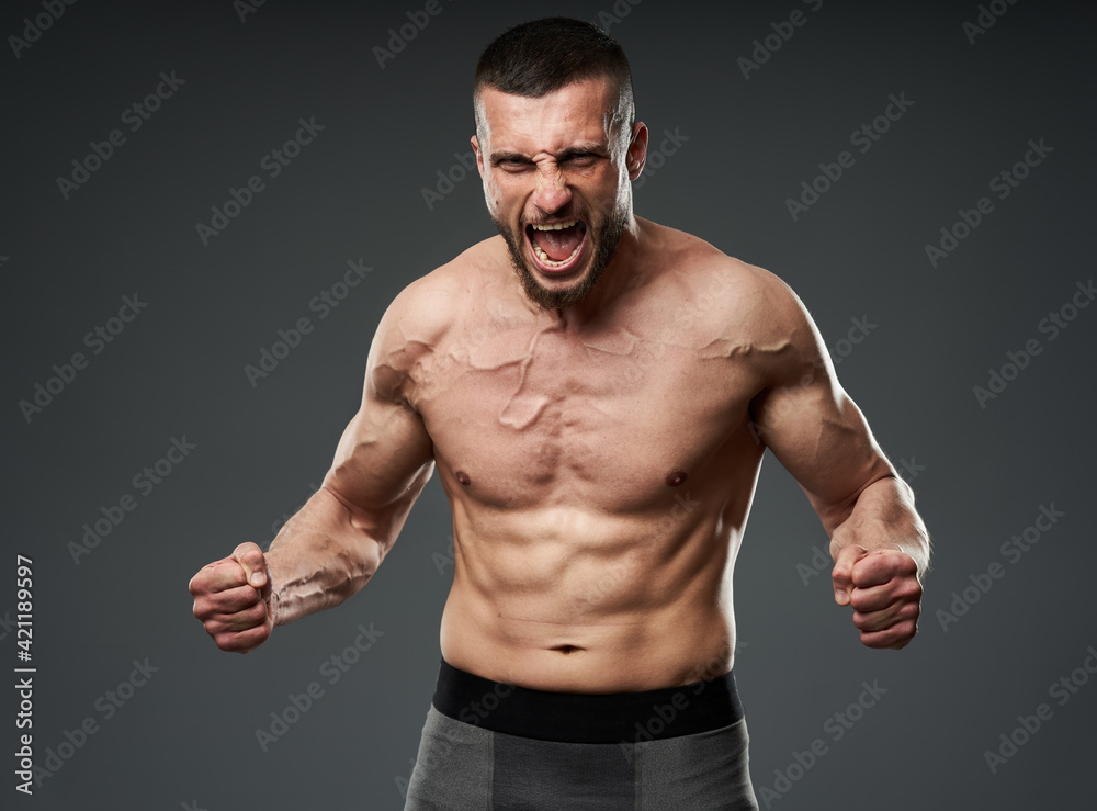 Fototapeta premium Athletic fighter posing on gray