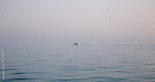 lonely boat in the blue ocean in the morning with gog in the background.