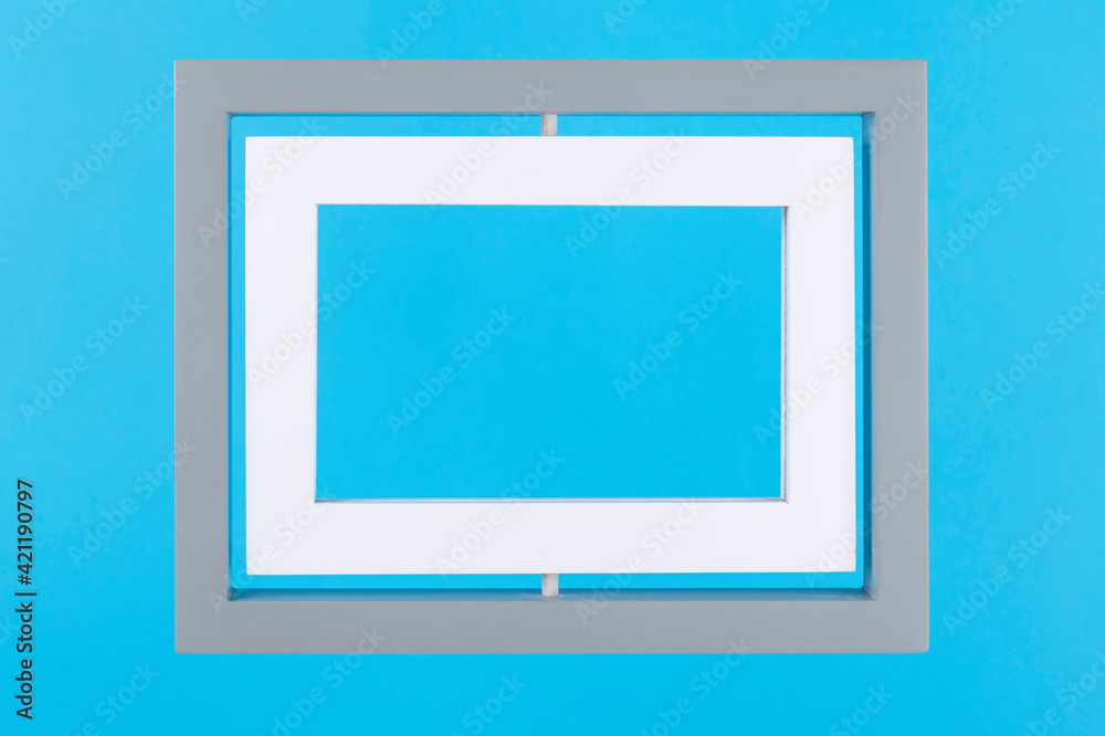 Grey and white double frame on pastel blue background. Minimal border composition