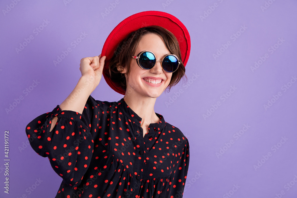 Portrait of attractive cheerful dreamy glad girl touching hat good day isolated over bright violet purple color background