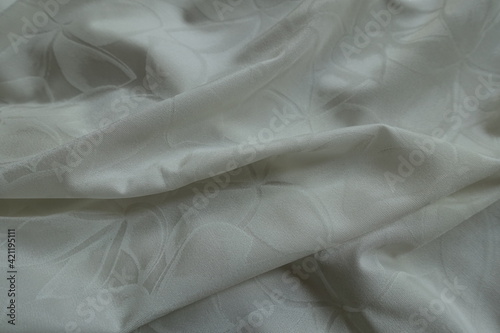 Folded thin white polyamide fabric with floral pattern