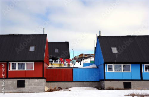 The laundry is hung between the houses that contrast red and blue in Ilulissat. photo