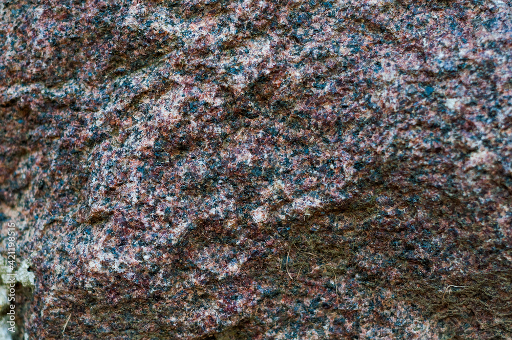 Chipped red gray granite stone close-up, beautiful texture, rough textured surface, exposure to atmosphere, outdoors. Chipped red gray granite stone close-up, beautiful texture, rough textured surface, exposure to atmosphere, outdoors.