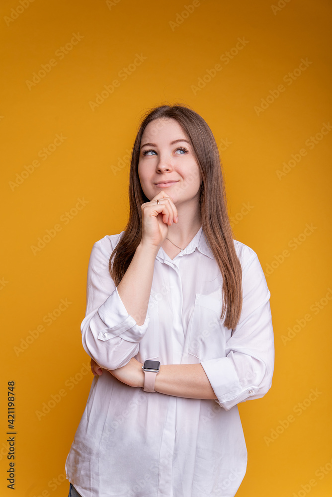 Close up photo of amazing lady looking up blank space, deep thinking creative man, hand on chin wears casual white blouse and jeans, isolated yellow color background Close up photo of amazing lady looking up blank space, deep thinking creative man, hand on chin wears casual white blouse and jeans, isolated yellow color background