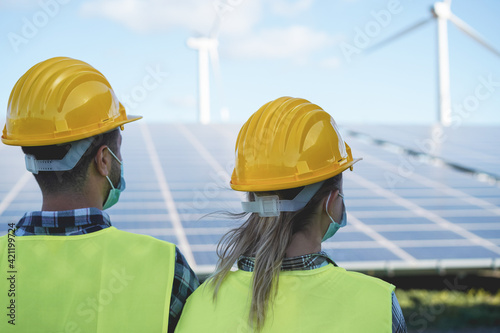 Industrial people working at solar power station while wearing safety masks - Focus on woman head