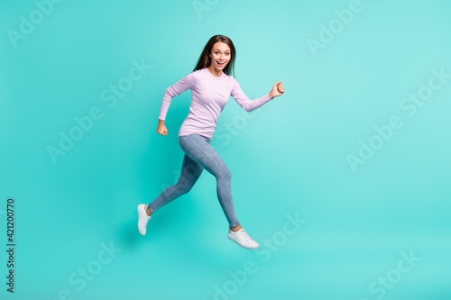Full length body size view of attractive cheerful girl jumping running fast speed isolated over turquoise bright color background