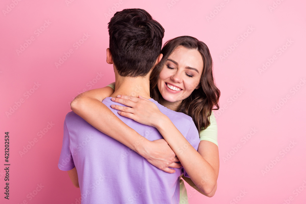 Portrait of attractive dreamy tender gentle amorous cheerful couple embracing isolated over pink pastel color background Portrait of attractive dreamy tender gentle amorous cheerful couple embracing isolated over pink pastel color background