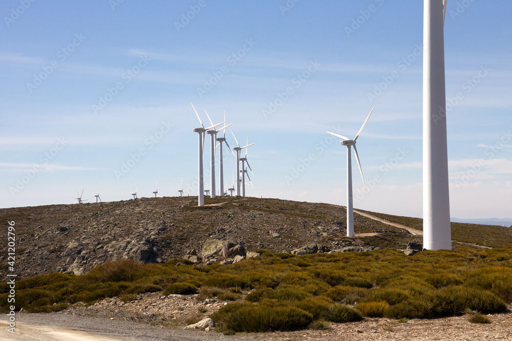 Clean electricity producing wind turbines built on a windy mountain ridge Clean electricity producing wind turbines built on a windy mountain ridge