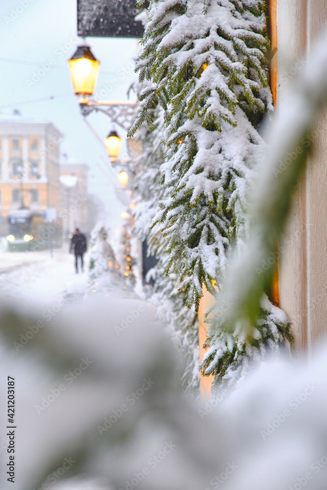 Aleksanterinkatu street during the strong snowstorm. Windows decorated with snow-covered spruce branches. The beautiful Christmas atmosphere in Helsinki, Finland.