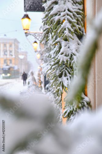 Obraz na płótnie Aleksanterinkatu street during the strong snowstorm. Windows decorated with snow-covered spruce branches. The beautiful Christmas atmosphere in Helsinki, Finland. w salonie