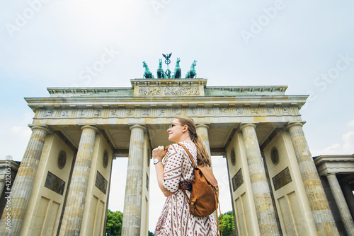 Canvas Print A tourist or a student with a backpack near the Brandenburg Gate in Berlin in Germany, looks at the sights