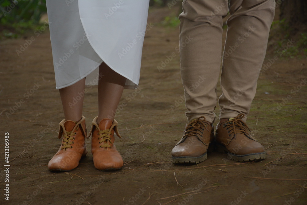 a close-up of the feet of a woman and a man walking on the sand. wedding photo concept.