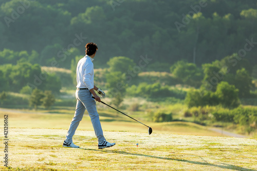 Golfer sport course golf ball fairway. People lifestyle man playing game golf tee off on the green grass.  Asian man player game shot in summer
