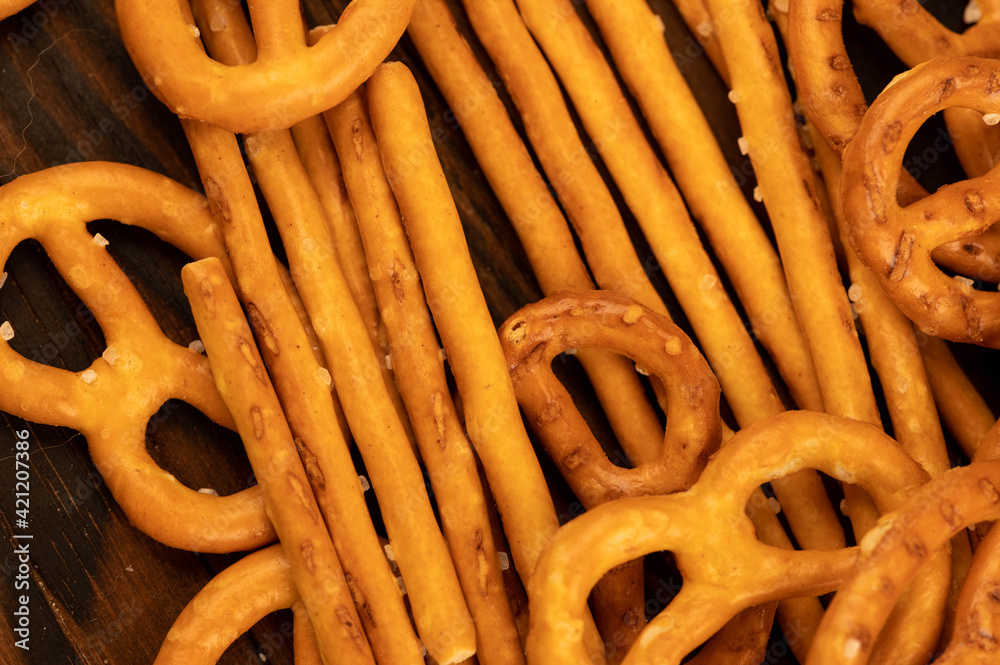 Salted breadsticks and salted pretzels scattered on the table. Salted breadsticks and salted pretzels scattered on the table.