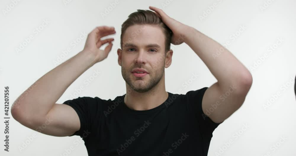 Attractive Happy Man styling Hair by Hands with Spray looking at the Camera. Young Man with trendy Haircut preparing for Date with Good Mood isolated on White Background. Feeling Satisfied. Attractive Happy Man styling Hair by Hands with Spray looking at the Camera. Young Man with trendy Haircut preparing for Date with Good Mood isolated on White Background. Feeling Satisfied.