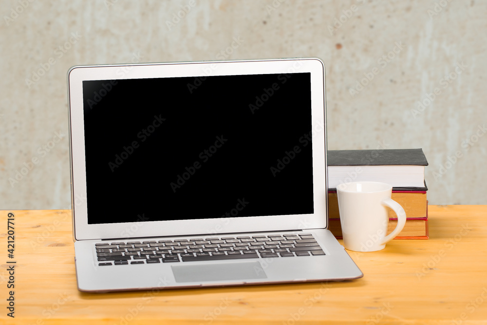 Laptop with blank screen, cup of coffee and books or notebooks on a wooden table. mockup for your text Laptop with blank screen, cup of coffee and books or notebooks on a wooden table. mockup for your text