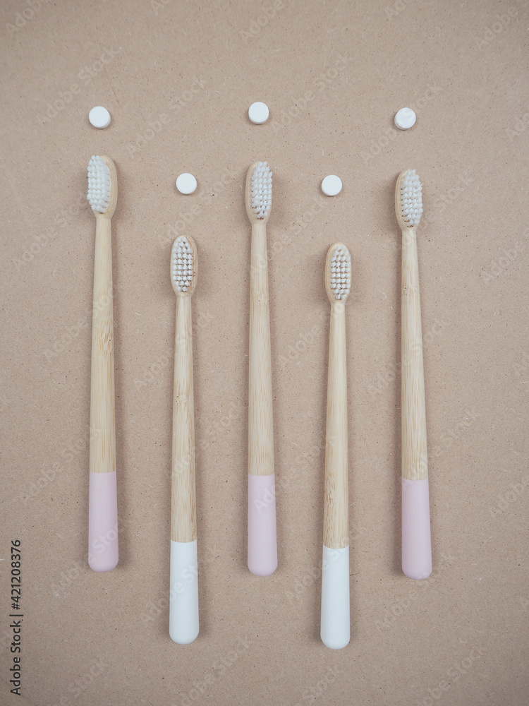 Bamboo toothbrush and dental tabs on a wooden background, plastic free swap. Bamboo toothbrush and dental tabs on a wooden background, plastic free swap.