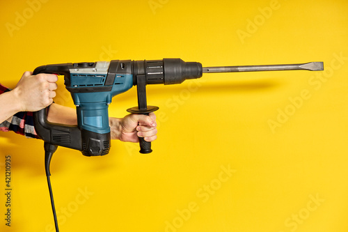 male holding green puncher for repair isolated on yellow