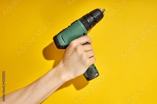 electric cordless screwdriver drill isolated on yellow background, professional home repair tool