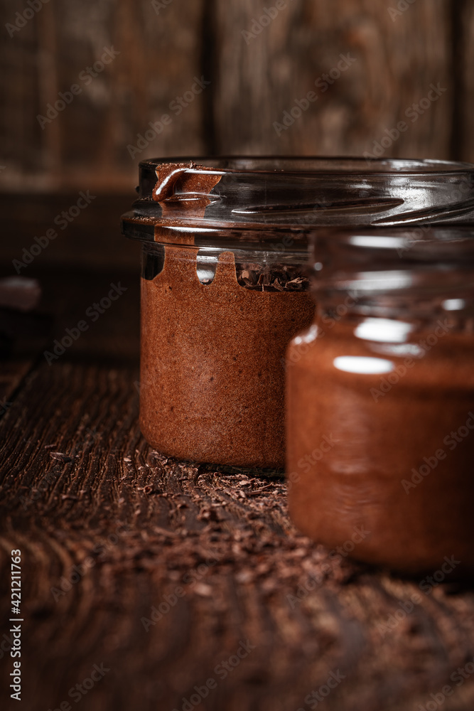 Homemade dark chocolate mousse in rural jars on rustic wood table Homemade dark chocolate mousse in rural jars on rustic wood table
