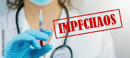 CORONAVIRUS: Ärztin mit Corona Impfung Spritze in der Hand und rotem zerkratzen Stempel / Aufkleber mit dem Wort 