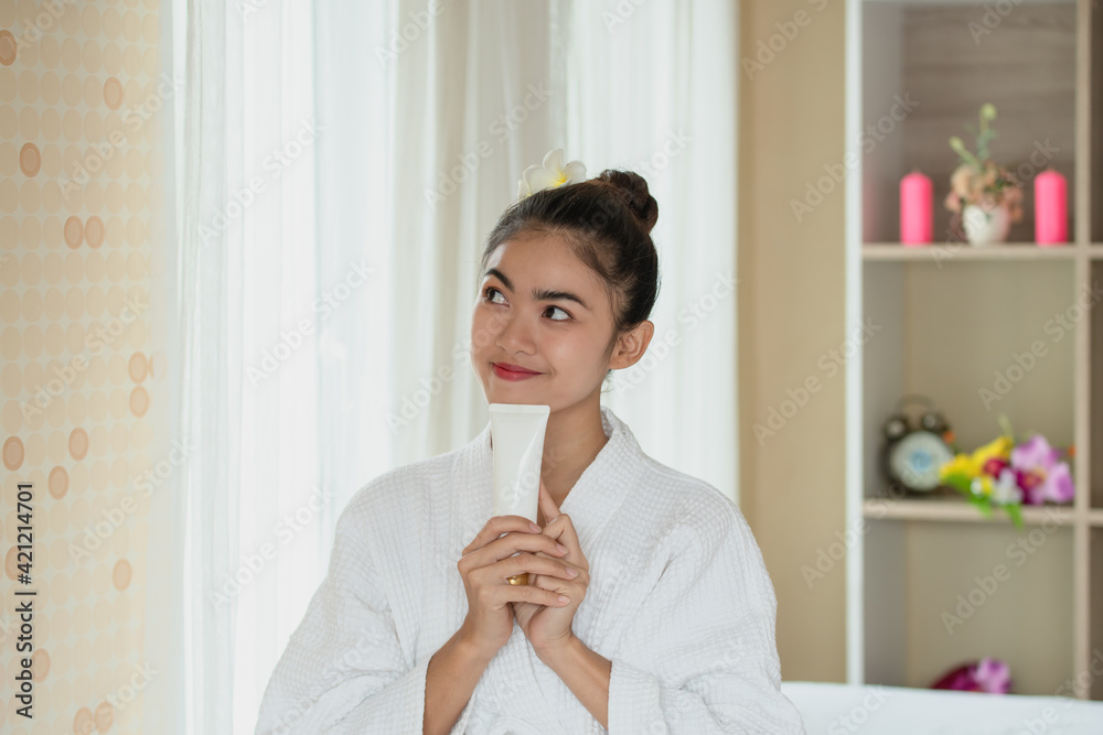 Pretty young Asian woman holding and presenting white cosmetic tube, Beauty skin care concept Pretty young Asian woman holding and presenting white cosmetic tube, Beauty skin care concept