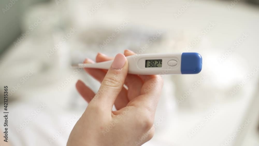 Male hands holding a digital thermometer with high temperature. Male hands holding a digital thermometer with high temperature.