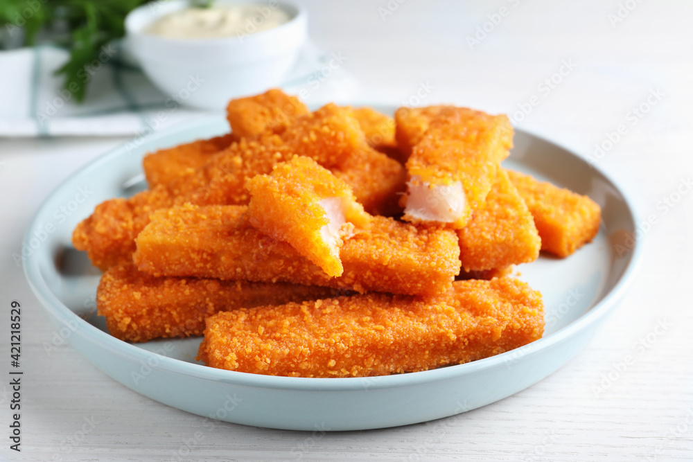 Fresh breaded fish fingers served on white table Fresh breaded fish fingers served on white table