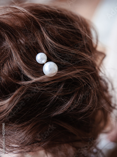 the hairdresser puts the girl's hair, jewelry made of pearls