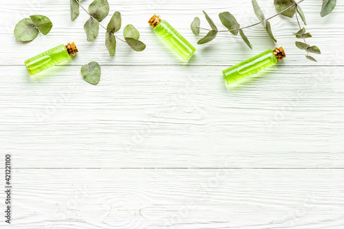 Glass bottles of herbal essential oil with eucalyptus leaves. Natural cosmetics products