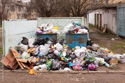 Full trash can. Trash can filled with trash. Trash can packed to overflowing with rubbish. The bin is filled with rubbish.