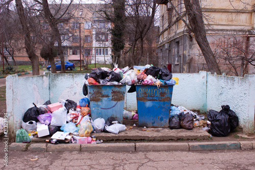 Full trash can. Trash can filled with trash. Trash can packed to overflowing with rubbish. The bin is filled with rubbish.