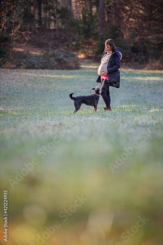 Pregnant woman outside in nature with her dog © Gajus