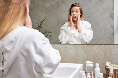 emotional female surprised with facial skin condition,look at mirror