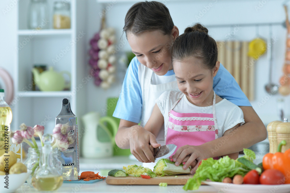 Cute brother and sister cooking together in kitchen Cute brother and sister cooking together in kitchen