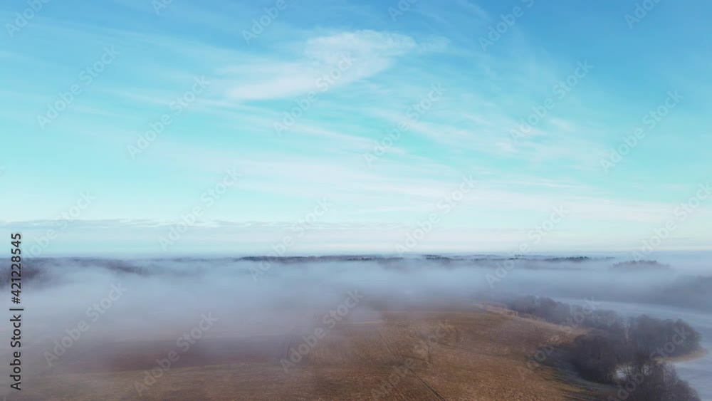Aerial view of foggy spring landscape and small village in sunny morning. Top view of beautiful European nature from high attitude. Bird's eye view 4K. Aerial view of foggy spring landscape and small village in sunny morning. Top view of beautiful European nature from high attitude. Bird's eye view 4K.