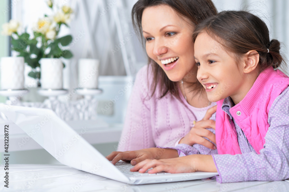 happy mother and daughter using laptop together happy mother and daughter using laptop together