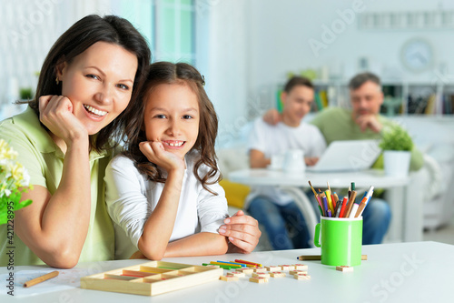 Cute little girl with her mother studying